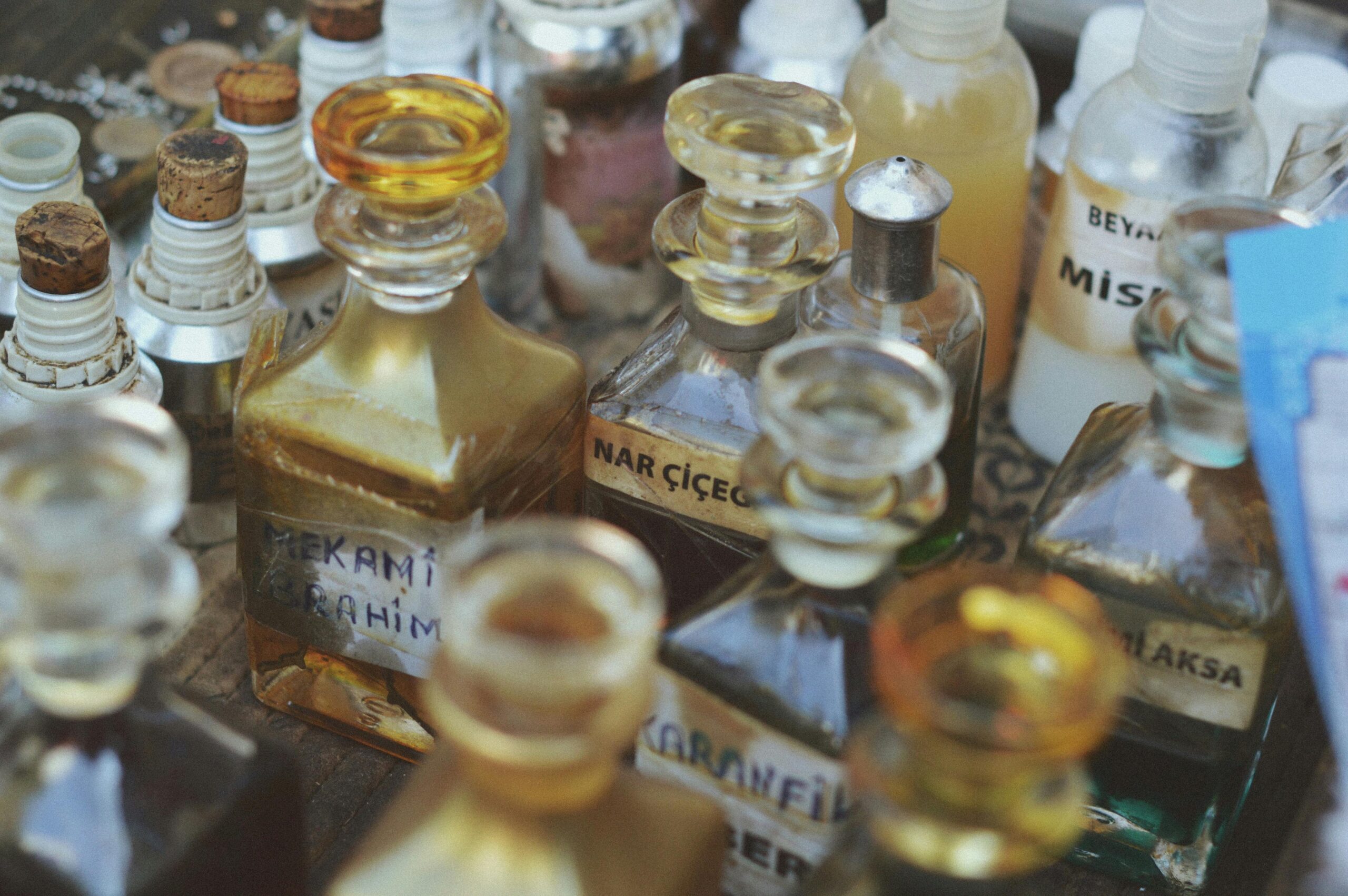 Trending perfumes in the UAE Collection of vintage glass perfume bottles with various labels in a close-up view.
